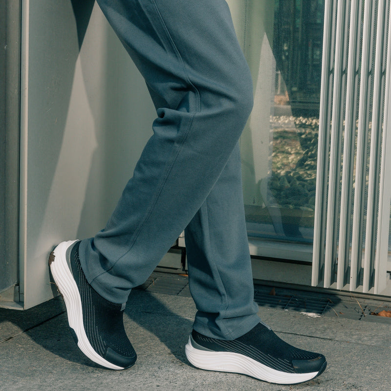 Angled profile view of the KURU ATOM 2 Slip-On Men's Slip-On Sneaker in Jet Black-Bright White.