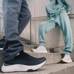 Back heel view of the KURU ATOM 2 Slip-On Men's Slip-On Sneaker in Jet Black-Bright White.