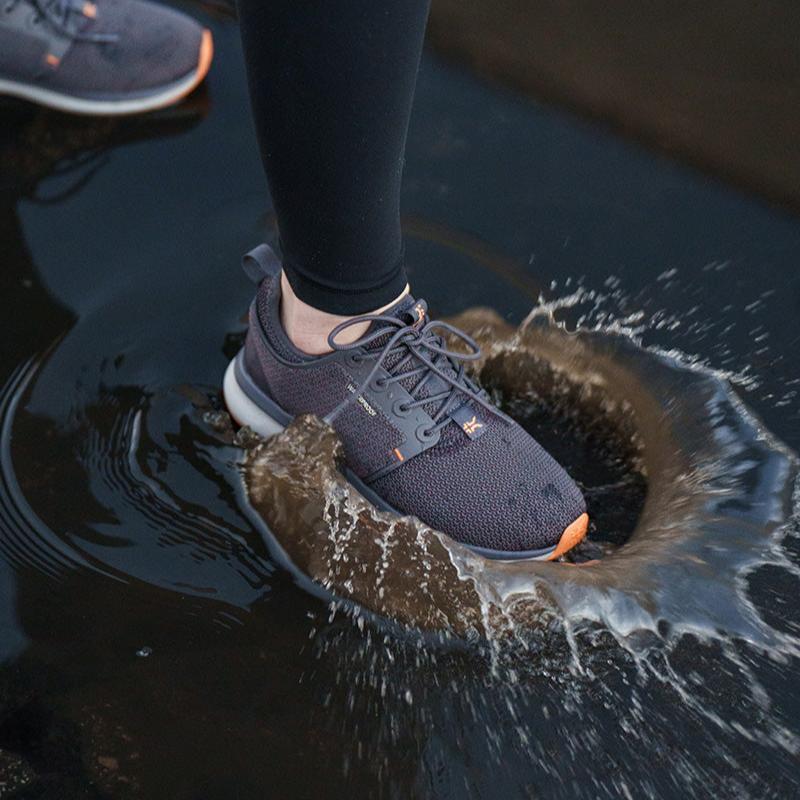 Woman wearing KURU ATOM WP Women's shoes in Gray, walking through puddles in winter conditions.