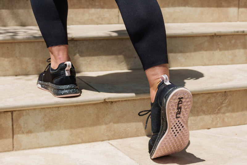Person caring for their KURU footwear to maintain comfort and extend the life of their shoes.