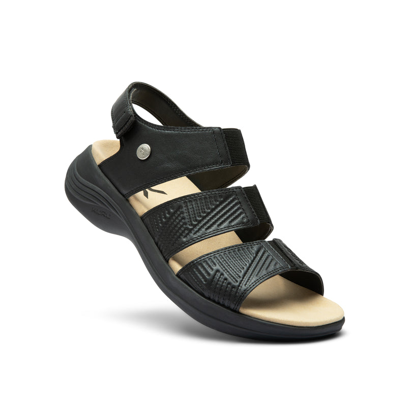 Angled profile view of the KURU CODA Muse Women's Sandal in Jet Black-Emboss.