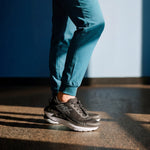 Angled profile view of the KURU CURA Unisex Shoe in Jet Black-Storm Gray.