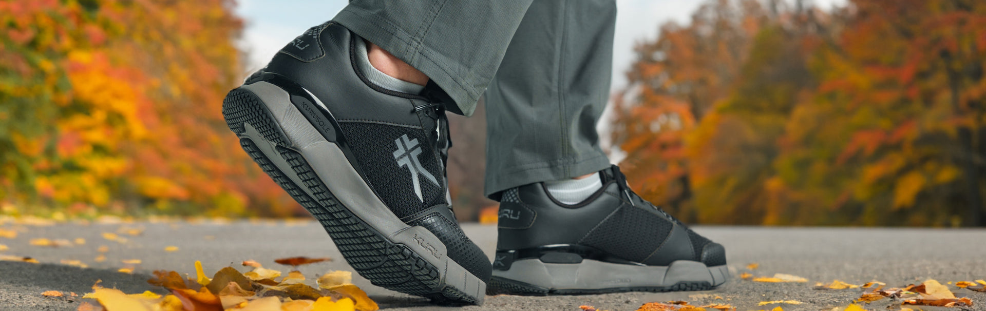 Person walking in KURU footwear in jet black, ideal for fall walks and everyday comfort.