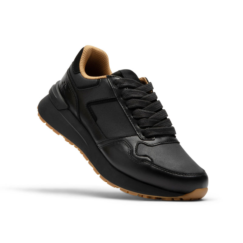 Side profile of the KURU APOGEE Luxe Unisex Leather Sneaker in Jet Black-Gum.