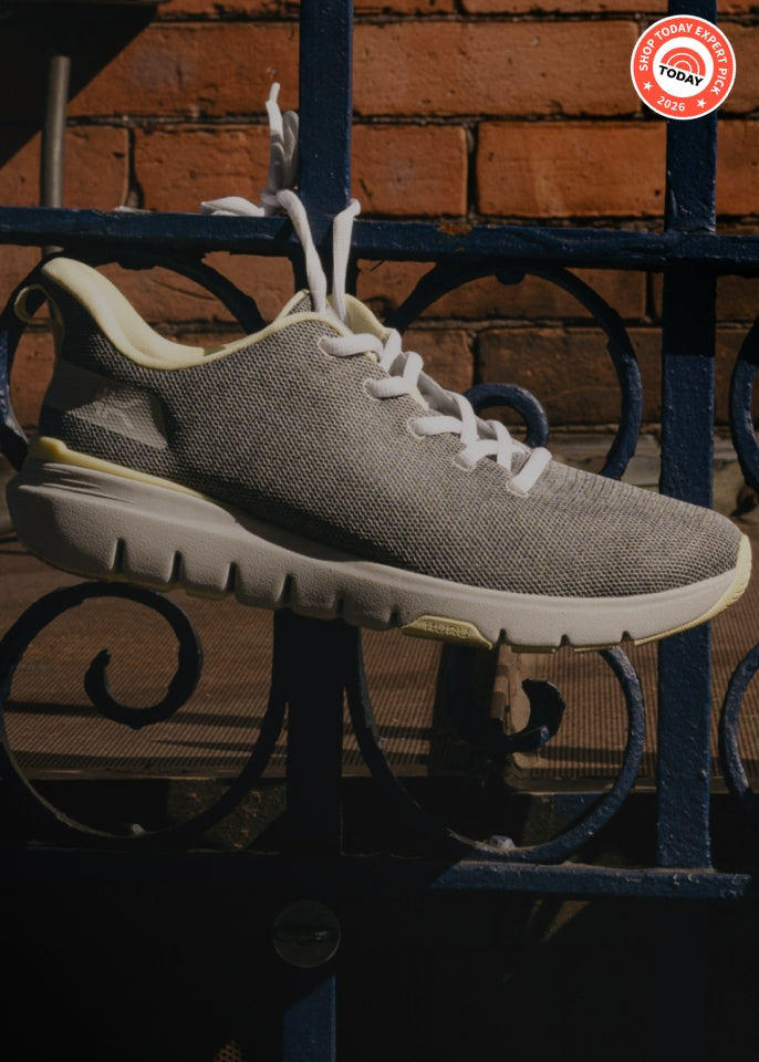 A pair of FLEX Via, hanging from a black wrought iron fence in front of a brick wall. A red circular 'Shop Today Exclusive' badge is in the top right corner.