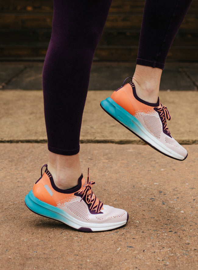 Woman working out doing high kicks, wearing KURU Footwear's FLUX shoes for alleviating foot pain
