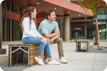 Male and female sitting on a wooden bench