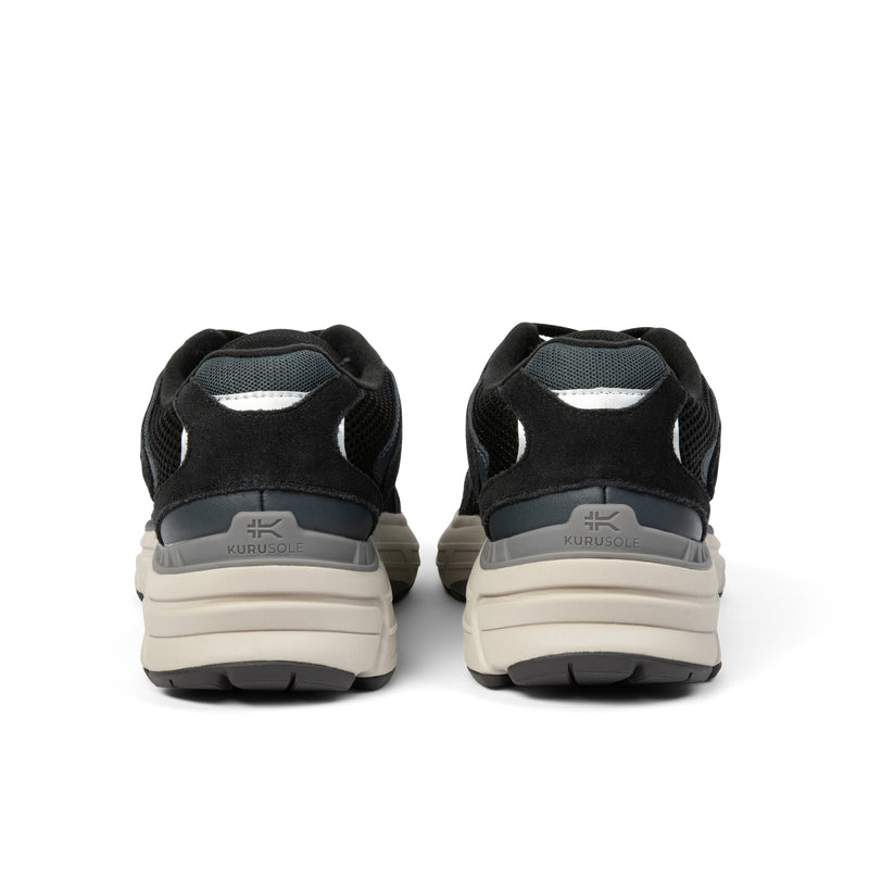 Back heel view of the KURU SURGE Unisex Sneaker in Jet Black-Bone Gray.