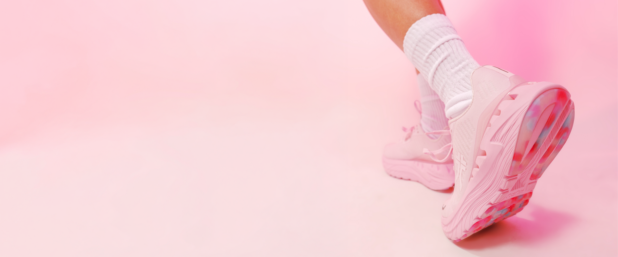 Person wearing KURU TRIPLE MAX Ion Women's Sneaker in Pink on a pink background.
