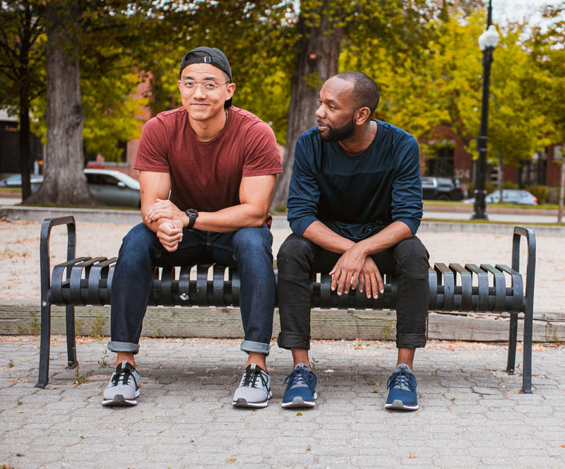 Two Men sitting on a Bench wearing Kuru Footwear